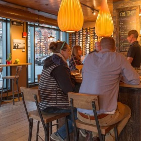 lifestyle image of people sitting at a bar with modern lighting