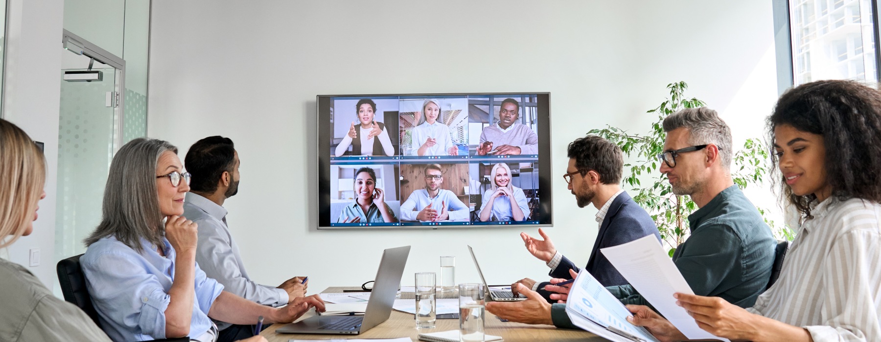 Group of coworkers in conference room participating in virtual meeting