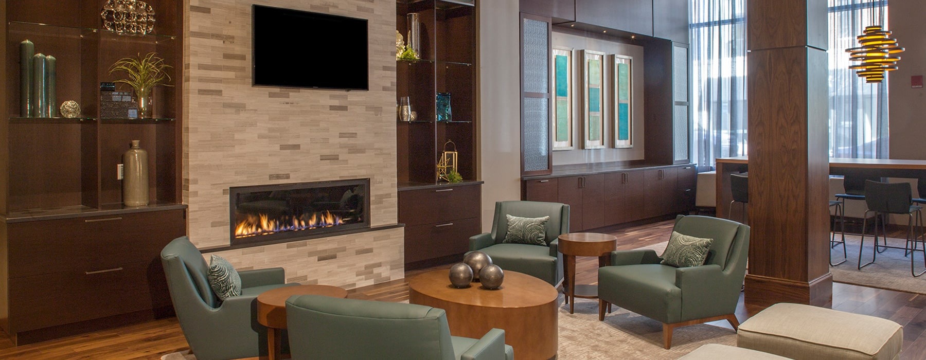 clubroom with modern seating, high-ceilings, a fireplace, wooden accents and modern decor